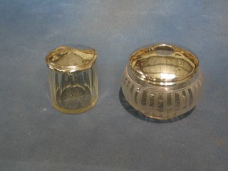 An Art Deco cut glass hair tidy with silver lid and a circular dressing table jar with silver lid (f)