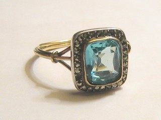 A 19th Century gilt metal ring set a square cut blue stone surrounded by marcasites