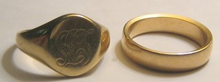 A gold wedding band and a gentleman's engraved gold signet ring