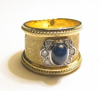 A Spanish gold dress ring set a cabouchon cut sapphire supported by 6 diamonds