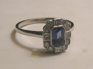 A lady's 18ct white gold dress ring set a rectangular cut sapphire surrounded by 12 diamonds (approx 0.37ct)