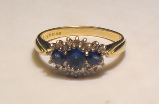A lady's 18ct gold dress ring set 3 oval cut sapphires surrounded by diamonds