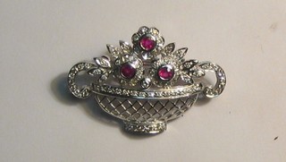 A pierced white gold brooch in the form of a twin handled basket of flowers, 3 flower heads set rubies and diamonds
