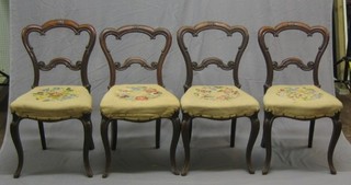 A set of 4 Victorian mahogany balloon back dining chairs with carved mid and cresting rails, the seats of serpentine outline, raised on cabriole supports (tired condition)