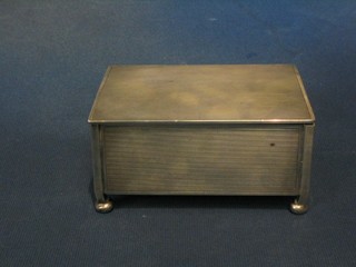 A rectangular Art Deco silver cigarette box with engine turned decoration raised on 4 bun feet, Birmingham 1940 5"