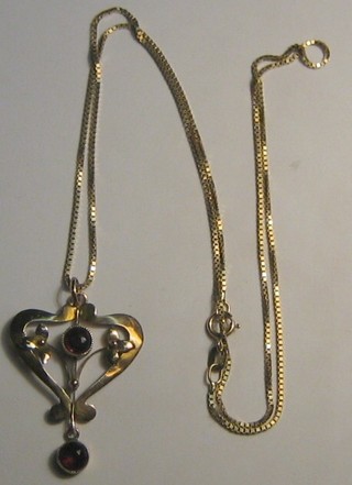 A lady's Edwardian pierced gold pendant set 2 red stones hung on a gold chain