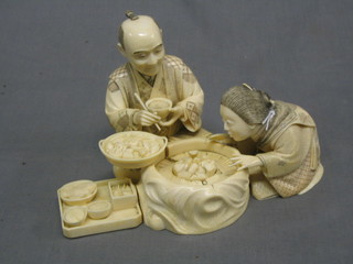 A handsome 19th Century Japanese carved ivory figure group of a couple feasting on oysters 9", the base signed (old crack to the centre)