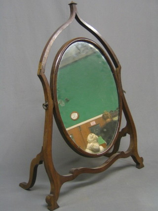 A Sheraton style oval plate dressing table mirror contained in a mahogany swing frame