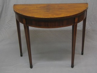 A Georgian carved mahogany demi-lune card table with crossbanded top, raised on square tapering supports ending in spade feet 36"