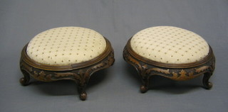 A pair of Victorian circular carved walnut framed foot stools on French cabriole supports 13"