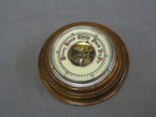 An aneroid barometer with porcelain dial contained in an oak socle case 6 1/2"