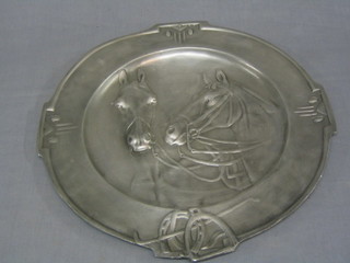A Continental embossed pewter charger decorated horses heads 15", the reverse with crown mark
