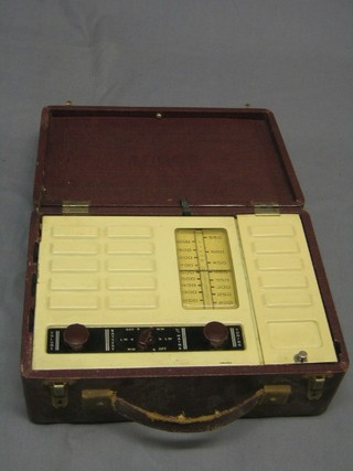 A Vidor portable radio contained in a red fibre carrying case