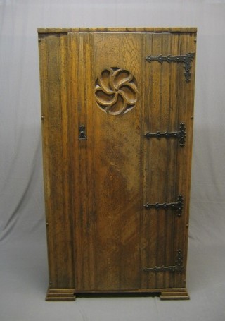 A 20th Century Gothic style carved oak hall wardrobe enclosed by a panelled door, 36"