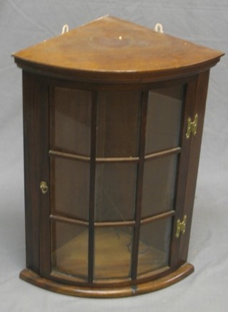A 20th Century Georgian style mahogany bow front hanging corner cabinet enclosed by a glazed panelled door 20"
