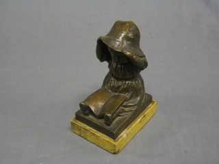 A bronze figure of a seated bonnetted child with book entitled "Margaret", the reverse monogrammed NTA, 5"