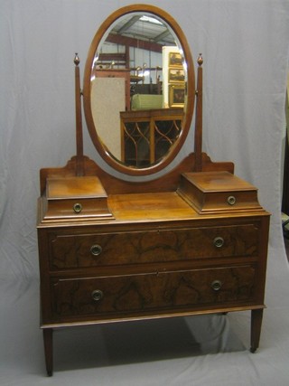 A 1930's figured walnut dressing chest with oval mirror, fitted 2 glove drawers above 2 long drawers, raised on square tapering supports 42"