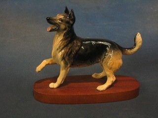A Royal Doulton figure of an Alsatian raised on an oval wooden base 8"
