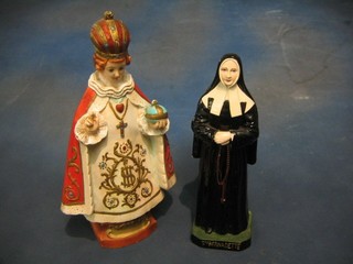 A plaster figure of St Bernadette and a plaster figure of Christ robed as a priest