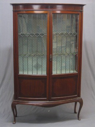 An Edwardian inlaid mahogany bow front display cabinet enclosed by lead glazed panelled doors, raised on cabriole supports 42"