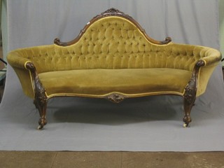 A handsome Victorian carved mahogany show frame sofa upholstered in buttoned yellow material raised on cabriole supports