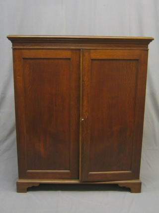 A 19th Century oak cabinet the interior fitted adjustable shelves enclosed by panelled doors and raised on bracket feet 37"