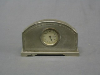 An Art Deco 8 day bedroom timepiece contained in a silver arch shaped case