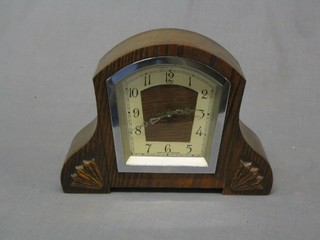 An Art Deco 8 day mantel clock contained in an arch shaped oak case with silvered dial and Arabic numerals
