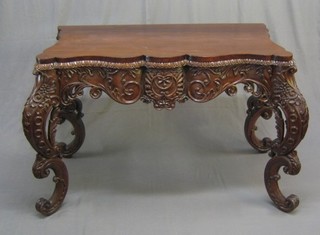 A Burmese heavily carved hardwood console table, raised on pierced cabriole supports 44"