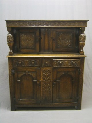 A good quality carved oak Jacobean style court cupboard, the upper section fitted a double cupboard enclosed by doors, the base fitted 1 long and 2 short drawers above double cupboard 50"
