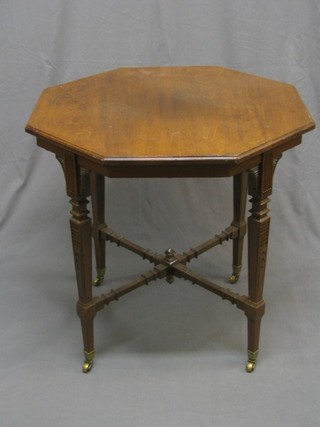  An Edwardian carved walnut octagonal occasional table raised on square tapering supports ending in brass caps and castors 31"