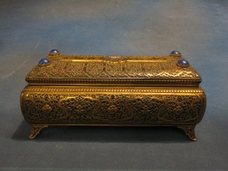 A handsome 19th Century Eastern embossed and engraved brass casket with hinged lid and enamel panel decorated a crowned sypher, the corners set lapis lazuli, raised on bracket feet, the base marked AP 11 1/2" (slight chip to left hand corner lapis) 