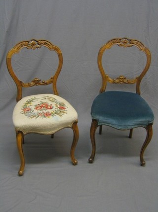 A pair of Victorian bleached walnut carved and pierced balloon back dining chairs with shaped mid rails, the seats of serpentine outline, raised on French cabriole supports