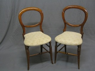 A set of 6 Victorian walnut balloon back bedroom chairs with upholstered seats, raised on turned supports