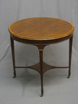 An Edwardian circular  mahogany and crossbanded occasional table with ebony stringing, raised on square tapering supports ending in spade feet, united by an undertier 30"