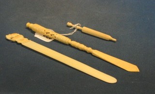 An  ivory needle case in the form of a parasol inset a Stanhope - A Present From Penmaenmawr, an ivory dip pen incorporating a paper knife with Stanhope - Souvenir of Torquay and an ivory paper knife