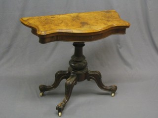 A Victorian figured walnut card table of serpentine outline, raised on turned column and tripod supports 37" (top heavily damaged)