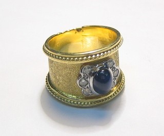 A Spanish gold dress ring set a cabouchon cut sapphire supported by 6 diamonds