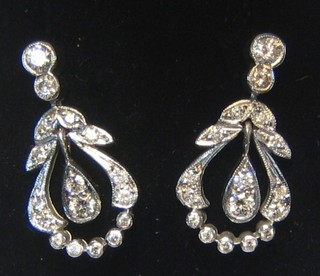 A very attractive pair of lady's drop earrings in the form of pierced leaves set diamonds (approx 0.65ct)