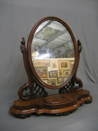 A handsome Victorian oval plate dressing table mirror raised on a carved and pierced stand, the base of shaped outline fitted a trinket box with hinged lid 31" (some spots to silvering on mirror)