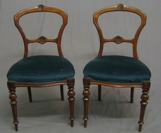 A set of 6 Victorian walnut balloon back dining chairs with carved cresting rail and mid rail, having upholstered seats and raised on turned and fluted supports (1 with very slight old worm to back leg)