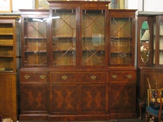 A handsome 20th Century Georgian style  triple breakfront library bookcase secretaire, the upper section with moulded cornice, the interior fitted adjustable shelves, the centre section fitted a secretaire drawer above 2 long drawers, flanked by 2 short drawers above double cupboards, raised on platform base 90"