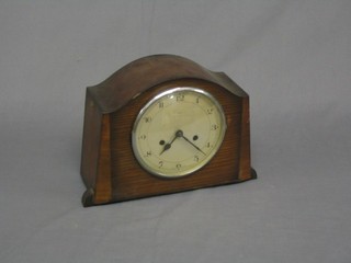 A 1930's 8 day striking mantel clock contained in an arch shaped oak case with silvered dial and Arabic numerals by Enfield