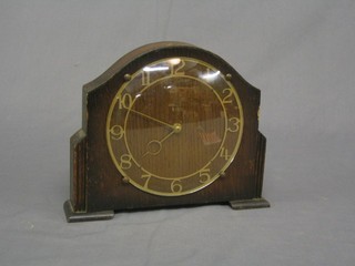 A 1930's Art Deco 30 hour mantel clock with pierced gilt metal dial contained in an arched oak case