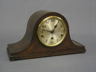 A 1930's 8 day chiming mantel clock with silvered dial and Arabic numerals contained in an oak Admiral's hat shaped case