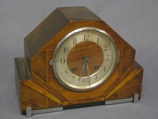 A 1930's Art Deco 8 day chiming mantel clock with silvered dial and Arabic numerals contained in an inlaid walnut case