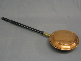 A Victorian engraved copper warming pan with turned ebony handle