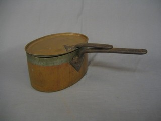 An oval copper saucepan and lid with iron handle