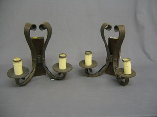 A pair of wrought iron twin light wall brackets