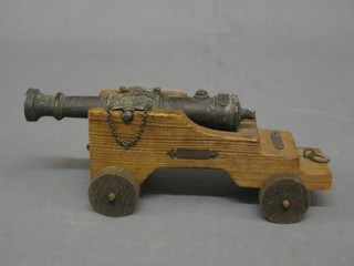 A  metal model of a 17th/18th Century canon with 8" metal barrel raised on a wooden trunion